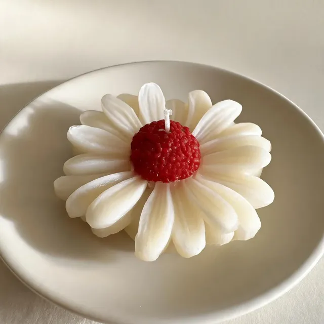 Single red centre daisy floating candle, on a ceramic plate, handmade by Felofey